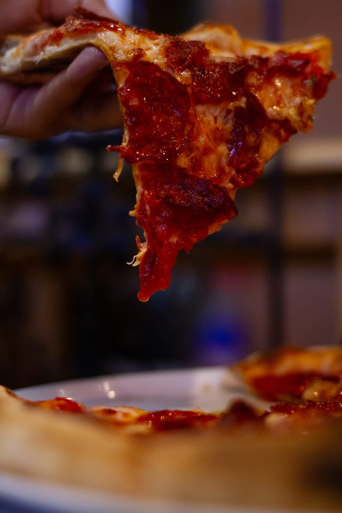 A slice of pizza lifted from the tray