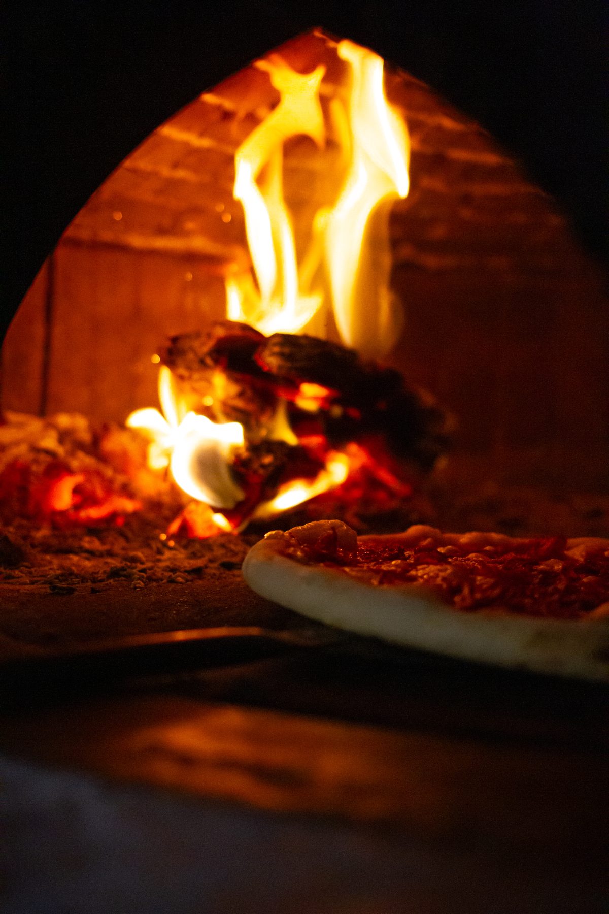 Pizza baking in the wood-fired oven